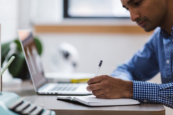 blurred Image of a person writing on a desk